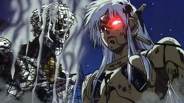 La periodista Sybel encara al cyborg M-66 entre chispas y humo en una escena de Black Magic M-66 (1987).