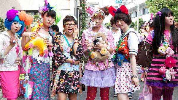Grupo de chicas japonesas vistiendo ropa colorida al estilo kawaii, con accesorios pastel y actitud alegre en una calle de Tokio.
