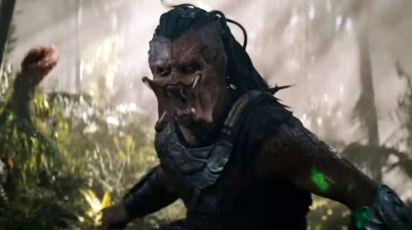 El Depredador en una escena de acción con ambientación selvática – versión 2025 del cazador alienígena en la película Tierras salvajes.