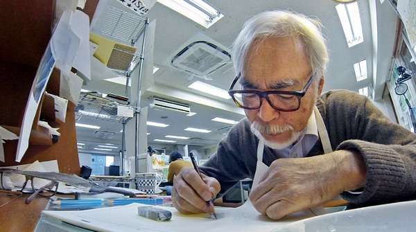 Hayao Miyazaki trabajando en su estudio de animación, rodeado de bocetos y material de dibujo durante el proceso creativo