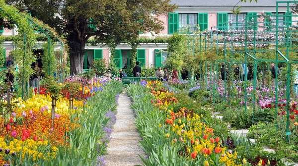 Casa de Claude Monet en Giverny, residencia del pintor impresionista rodeada de vegetación y jardines.