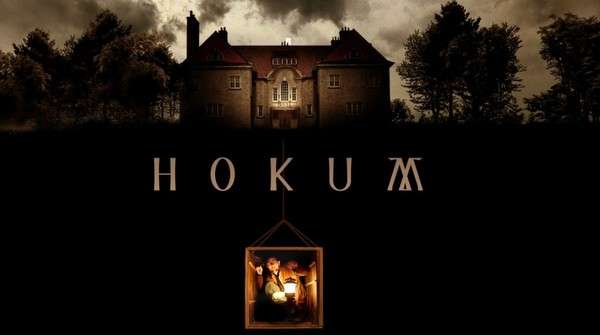 Póster de Hokum con una casa tenebrosa en un entorno oscuro y misterioso