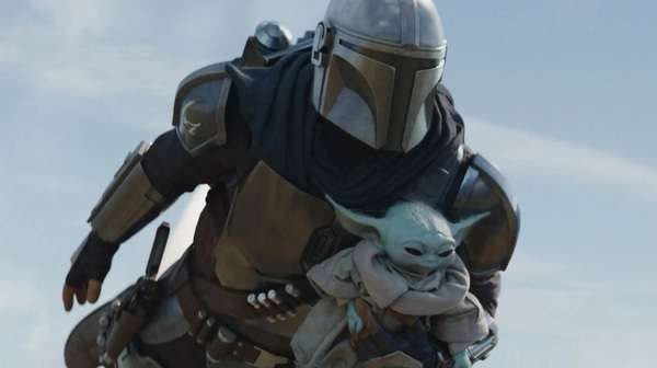 Mandalorian vuela con Grogu en brazos en una escena de acción de la película